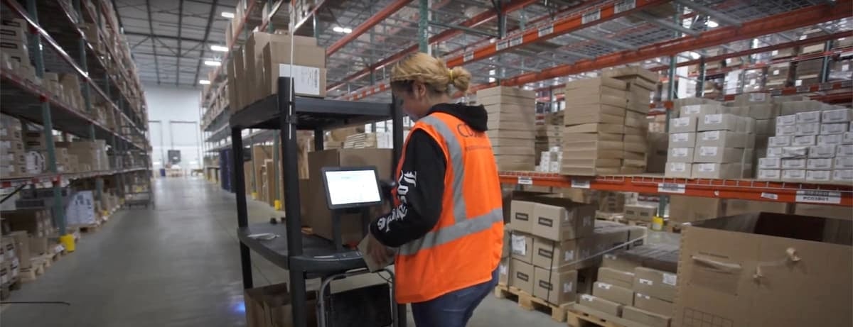 CDS warehouse team member using a warehouse management system to process inventory inside a large distribution center, illustrating Customized Distribution Services’ 3PL warehousing, inventory accuracy, and fulfillment operations.